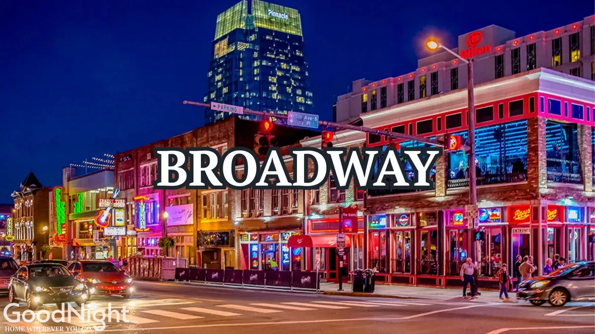 This exterior street scene captures Nashville nightlife with illuminated signs, colorful buildings, and bustling crowds. The atmosphere is lively, energetic, and distinctly urban—inviting guests to immerse themselves in the city's famous evening scene.