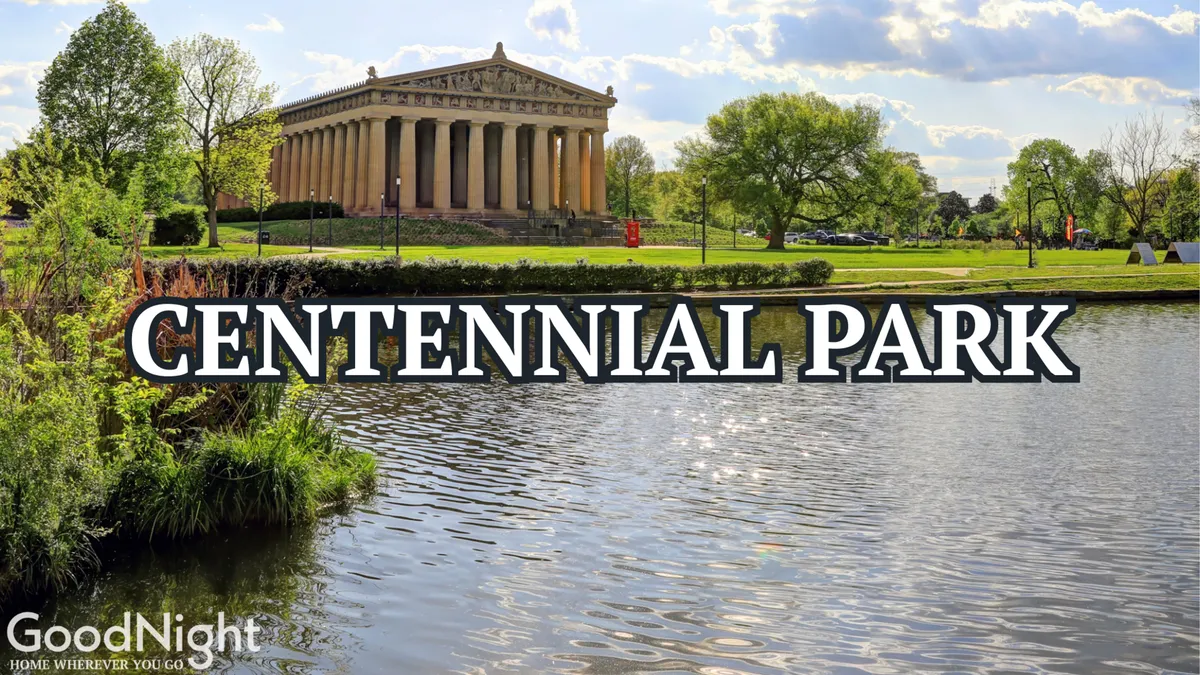 An exterior view of the Parthenon replica in Centennial Park, surrounded by lush greenery and a reflective water surface. The iconic columns and serene park setting are captured, evoking a sense of history and family-friendly outdoor activity.