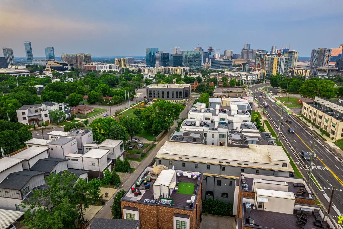 A panoramic city view featuring the Nashville skyline, green parks, modern architecture, and bustling streets. The perspective captures Nashville’s vibrant energy and places the home within its dynamic, desirable district.